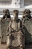 Bangkok Wat Arun - Detail of the precint of the sacred area of the ubosot with chinese noble man sitting on chair. 